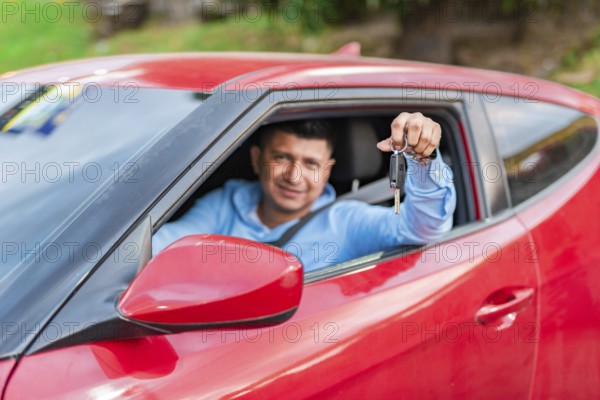 Smiling driver showing car key. Young male driver showing the keys to his car