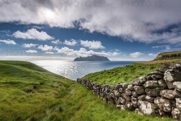 View of the island of Mykines, old stone wall, Gásadalur village, Vágar, Faroe Islands, Denmark,