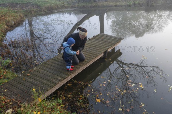 Mother with little son at a bathing jetty in the early morning, Othenstorf, Mecklenburg-Vorpommern,