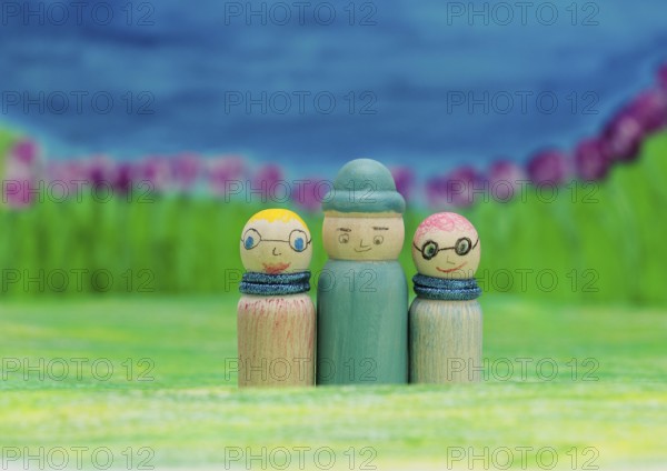 Three funny painted wooden cones in front of a painted background, North Rhine-Westphalia, Germany,