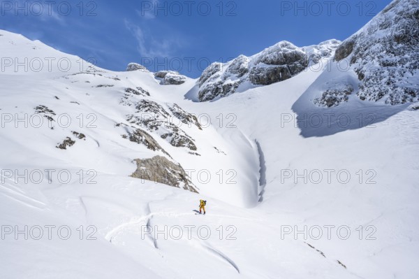 Lone ski tourer in mountain landscape with snow, ascent to Wildstrubelhütte, Bernese Alps,