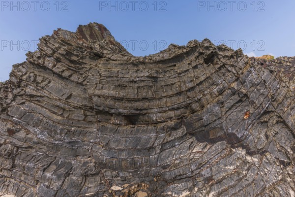 A rock with many holes and caves. Strange shapes in volcanic rock. Crozon, Brittany, Finistere,