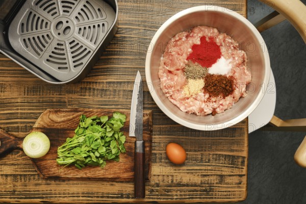 Ground meat is mixed with various spices, fresh cilantro, and chopped onion on a wooden cutting
