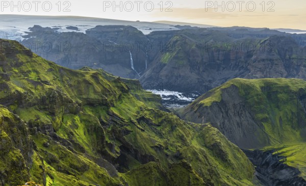 Moss-covered mountains at sunset, waterfalls on a cliff at Myrdalsjökull glacier, Pakgil, Iceland,