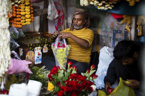 Vendor makes rose bouquet to sell in a street flower shop, on the occasion of Valentines day on