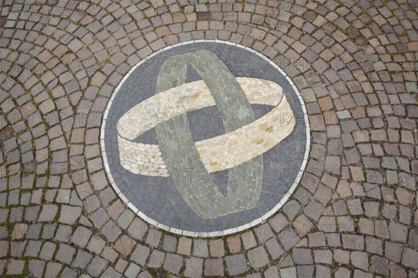 Two round rings with floor mosaic as a symbol of connectedness, paving stones, tyres, circles, into
