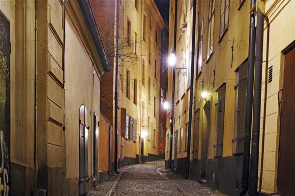Night shot of a cosy street with old buildings and warm lantern light in a city, winter, Gamla