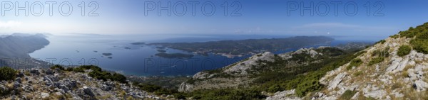 Panoramic view over a coastline with islands (Korcula) and mountains in the background under a