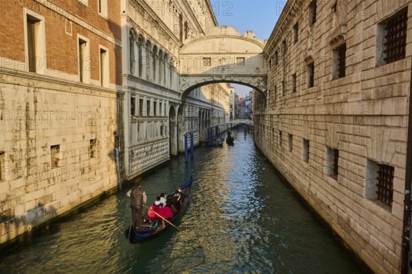 View from 'Ponte della paglia' on the bridge 'Bridge of Sighs' over a waterway on a sunny morning