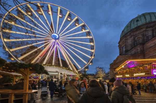 Ferris wheel at the winter village, Christmas market at dusk, St Elisabeth's Church on the right,