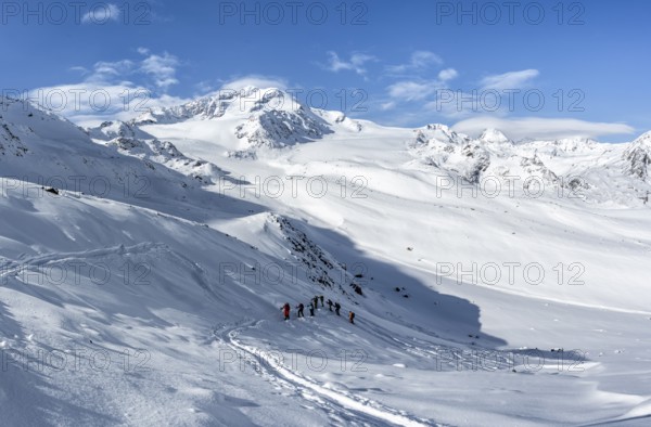 Ski tourers, behind the summit of Monte Cevedale, snow-covered mountain landscape, Ortler Alps,