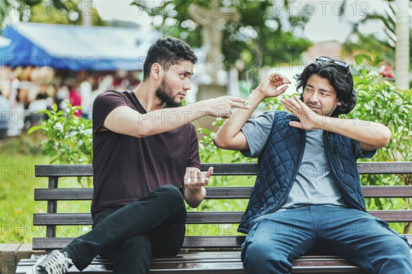 Young man sitting refusing a cigarette in the park. Disgusted guy sitting refusing a cigarette