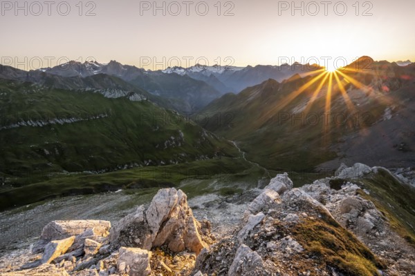 Mountain landscape at sunrise with sun star, view of mountain peaks of the Venediger group and into