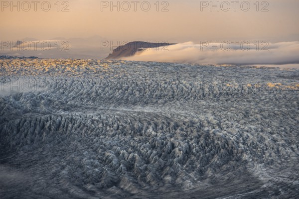 Fog, clouds moving around, glacier ice of the Kötlujökull glacier tongue at sunset, Myrdalsjökull