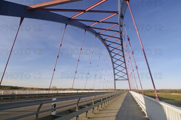 Modern bridge with blue and red struts under a clear sky, symbol of German unity, Dömitzer Brücke,