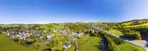 Aerial view of the village in autumn with Markersbach viaduct and bridge of the federal road 101