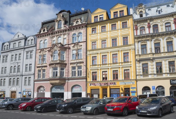Row of colourful, historic houses under a blue sky, parked cars in front, Liberec, Reichenberg,