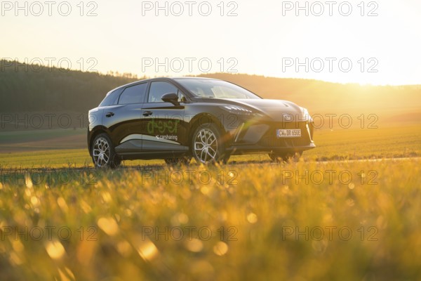 Black SUV parked in a meadow at sunset, natural surroundings, e-car sharing vehicle from Deer