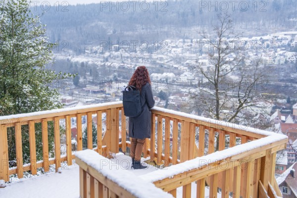 View of a snowy winter landscape from a vantage point with wooden fence, New wooden walkway in Calw