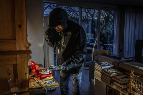 Symbolic image of a burglary, perpetrator has broken into a flat from the garden side and is