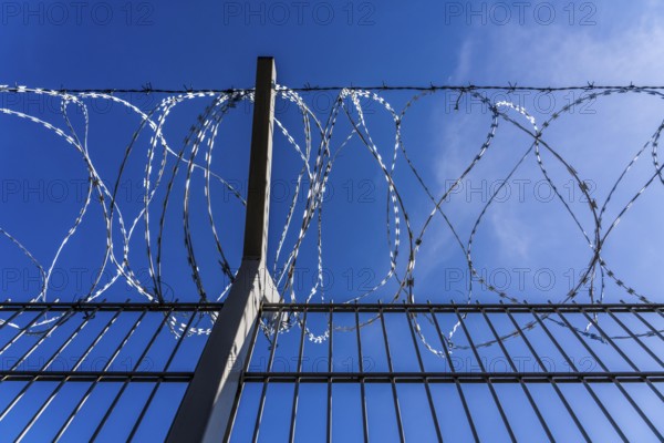 Symbolic image security, S-wire rolls, NATO wire, on a fence top, demarcation of a property,