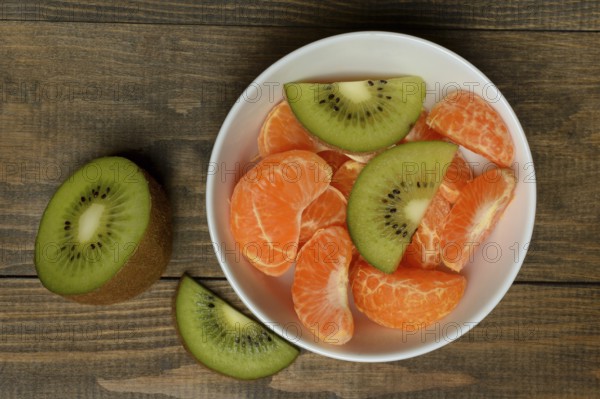 Clementine pieces and kiwi slices in peel