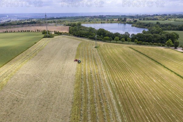 Aerial view of the Oberwartha reservoir, in the foreground a tractor with rake swathing hay,