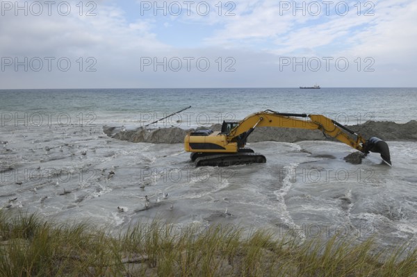 Excavators working to reclaim land on the beach of the Darß peninsula, Mecklenburg-Western