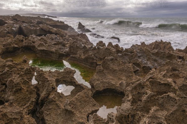 The rocks are scattered throughout the area, with some of them being large and jagged. The water