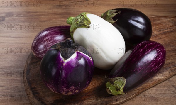 Colored eggplants, on a wooden table, white, purple and black eggplants, top view, raw eggplants,