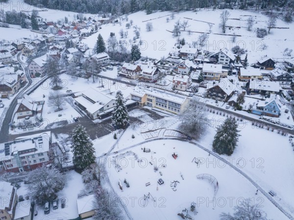 Snowy village with playground, surrounded by hills and trees, Enzklösterle, Calw district, Black