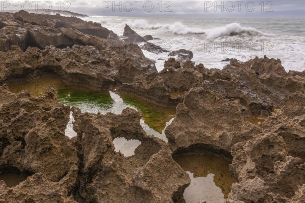 The rocks are scattered throughout the area, with some of them being large and jagged. The water