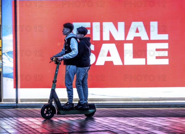 2 teenagers on an e-scooter, final sale, clothing department stores' on Schadowstraße, large poster