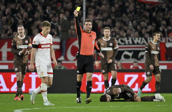 Referee Dr Felix Brych shows Yannik Keitel VfB Stuttgart (05) yellow card yellow caution for foul
