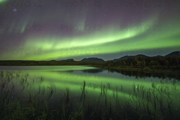 Northern lights reflected in lake, Lapporten, Abisko National Park, Lapland, Sweden, Europe
