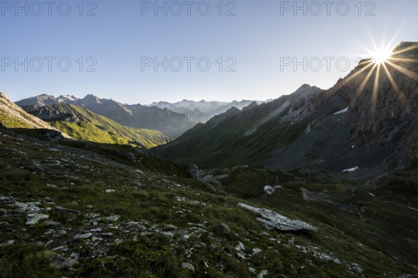 Mountain landscape at sunrise with sun star, view of mountain peaks of the Venediger group and into