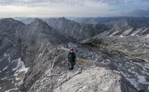 Mountaineer with helmet on a narrow rocky ridge, crossing the Jubiläumsgrat, Wetterstein range,