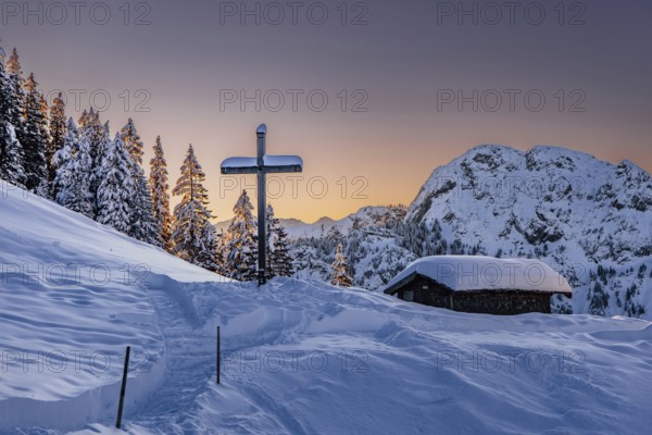 Hut and summit cross, sunrise snow tour on the Tegelberg in the Allgäu in Bavaria. Winter Wonder