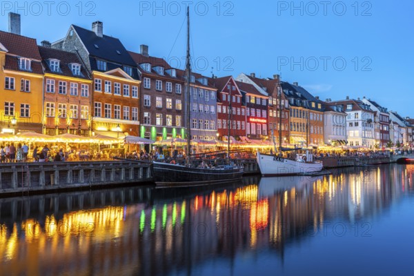 Colourful houses, restaurants and historic ships on the Nyhavn canal and harbour at dusk,