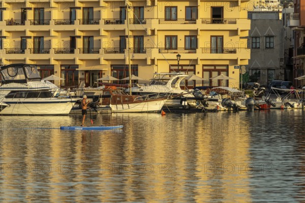 Stand-up paddlers in the harbour of Chania, Crete, Greece, Europe