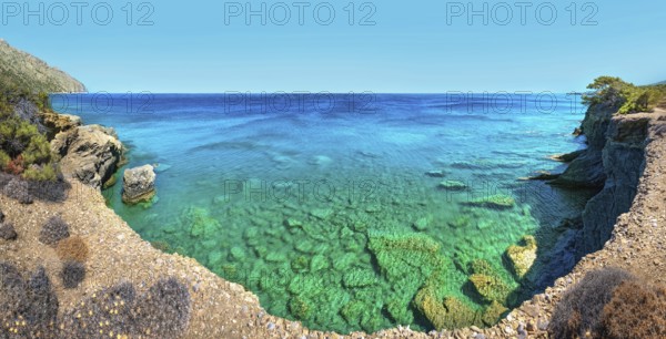 Clear blue water meets rocky coastline under a blue sky, hiking trail from Avlona to Diafani,