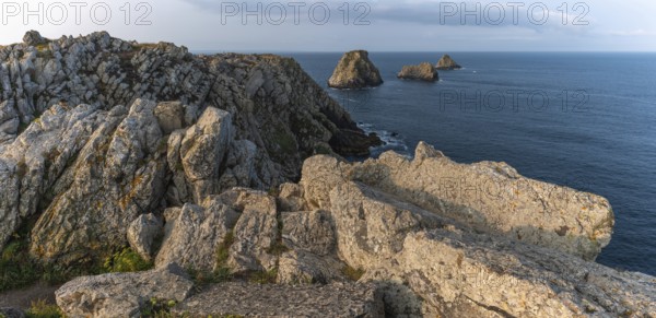 The tip of Pen Hir and its peach stacks. The rocks are jagged and rough, while the water is calm.