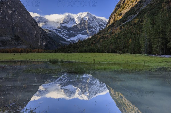 Snow-covered mountains reflected in lake, pond, autumn, Großer Ahornboden, Karwendel Mountains,