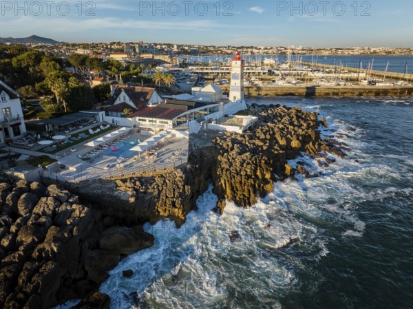 Aerial view of Santa Marta lighthouse and Cascais marina with moored yacht boats with Cascais