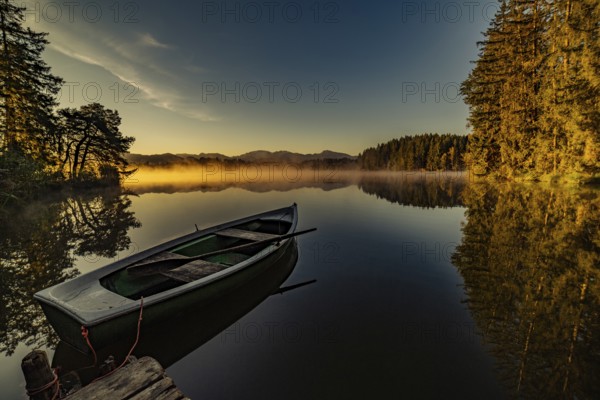 Boats in the autumnal Schmutter Weiher in the Allgäu near the municipalities of Halblech,