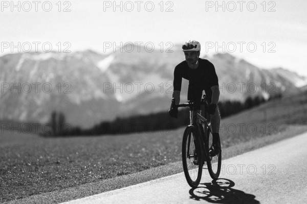 Road bike rider in spring near Halblech in the Allgäu in front of a picturesque backdrop of the
