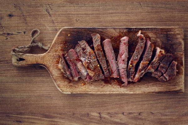 Medium rare, sliced rib eye steak, grilled cowboy steak, on a chopping board, close-up, homemade,
