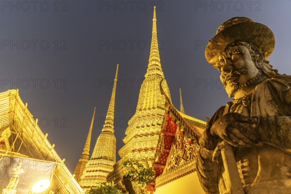 Giant Farang Guard and Chedi of the Buddhist temple Wat Pho at dusk, Bangkok, Thailand, Asia