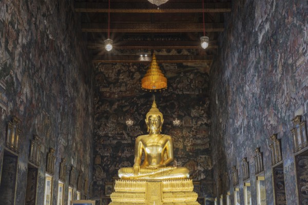 Golden Buddha statue, Phra Buddha Trilokachet, surrounded by exquisite murals, interior view of the