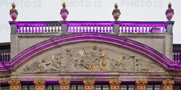 The illuminated gable of the guildhall Le Moulin à Vent and Pot d'Étain in the evening,